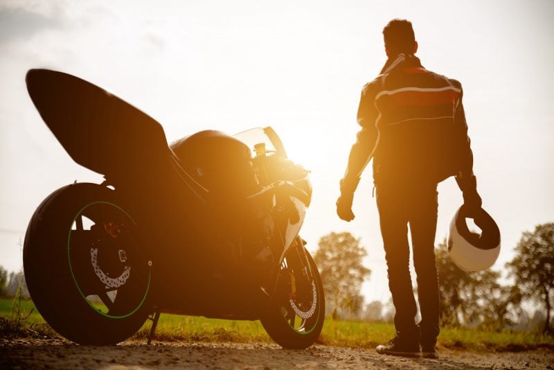 Bild eines GPS-Trackers für Motorräder neben einem Fahrer