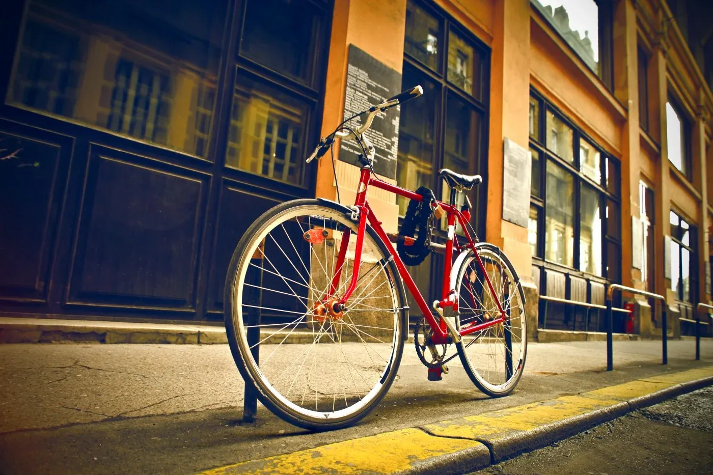 Rotes Fahrrad mit unauffälligem GPS-Tracker steht vor dem Laden