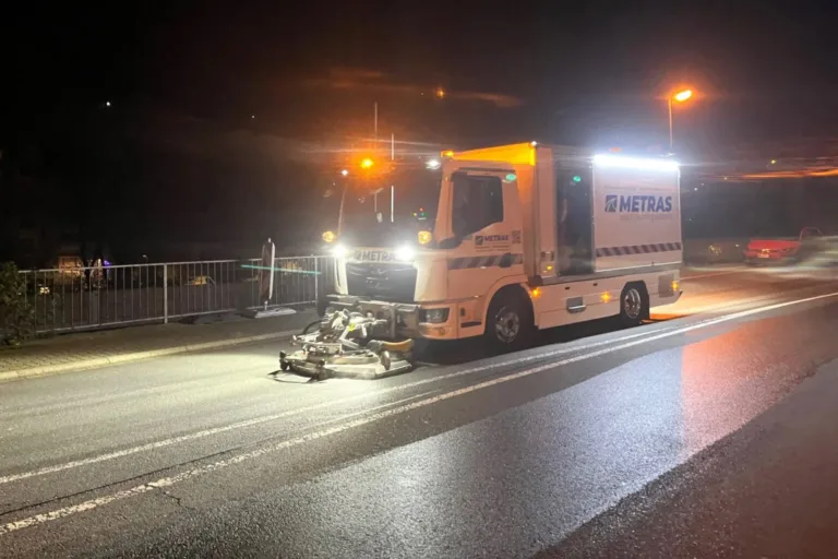 METRAS Einsatzfahrzeug beseitigt bei Nacht eine Ölspur auf nasser Fahrbahn